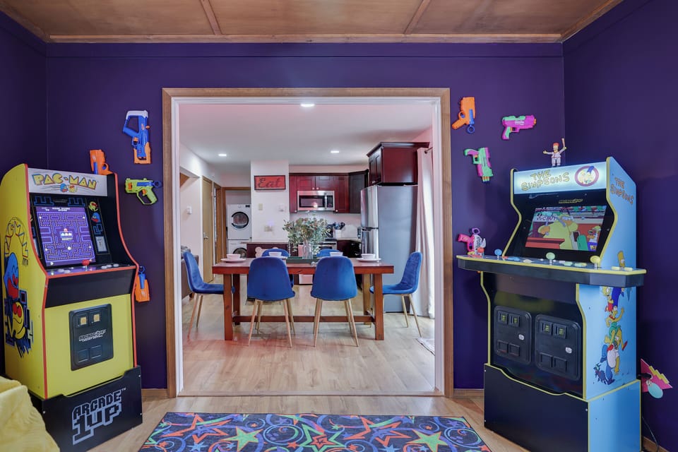 View of dining area and kitchen from the retro arcade room