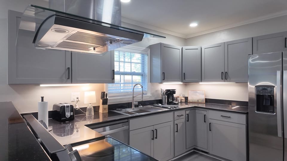 Modern kitchen with sleek stainless steel appliances, fully equipped for cooking and dining. Perfect for extended stays 