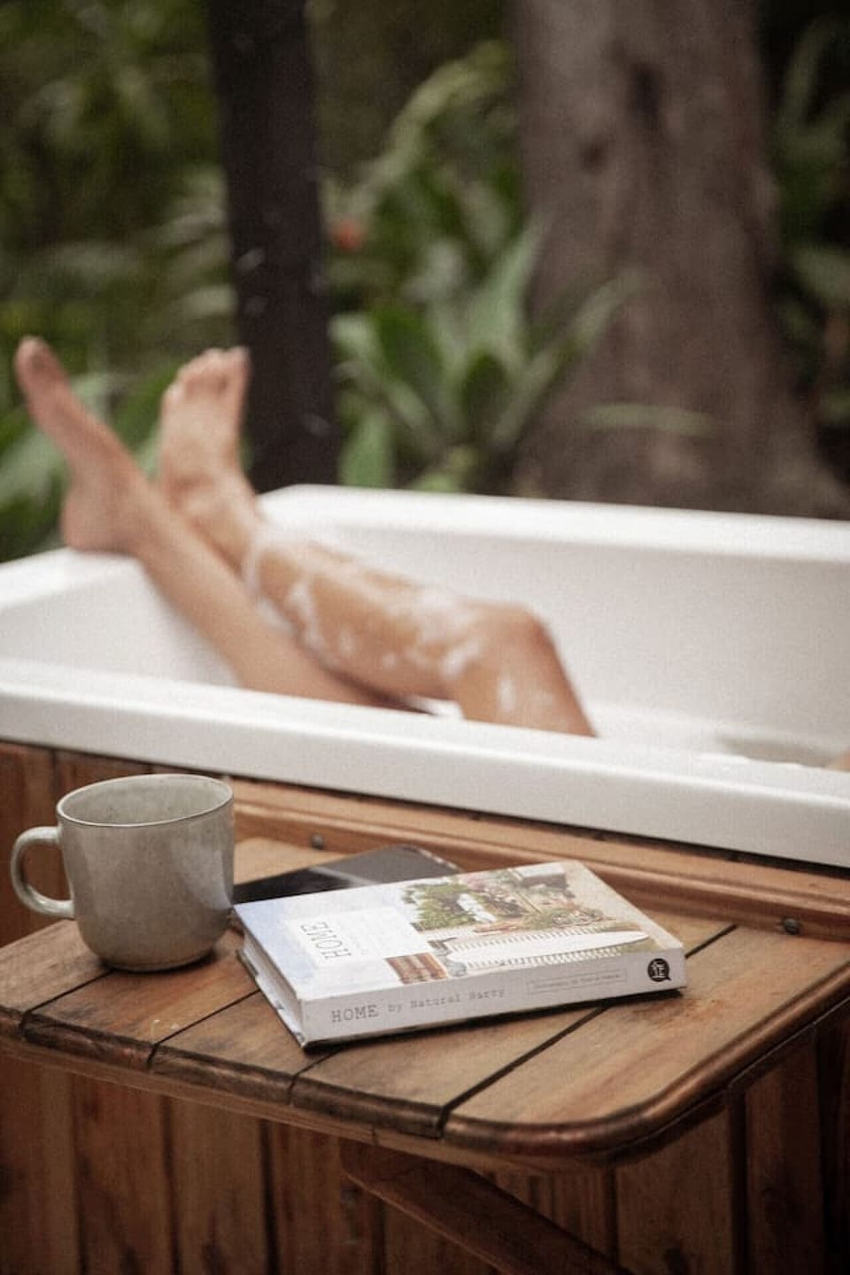 The handmade outdoor bathtub features a charming side table, perfect for holding your drink and nibbles while you unwind in style.