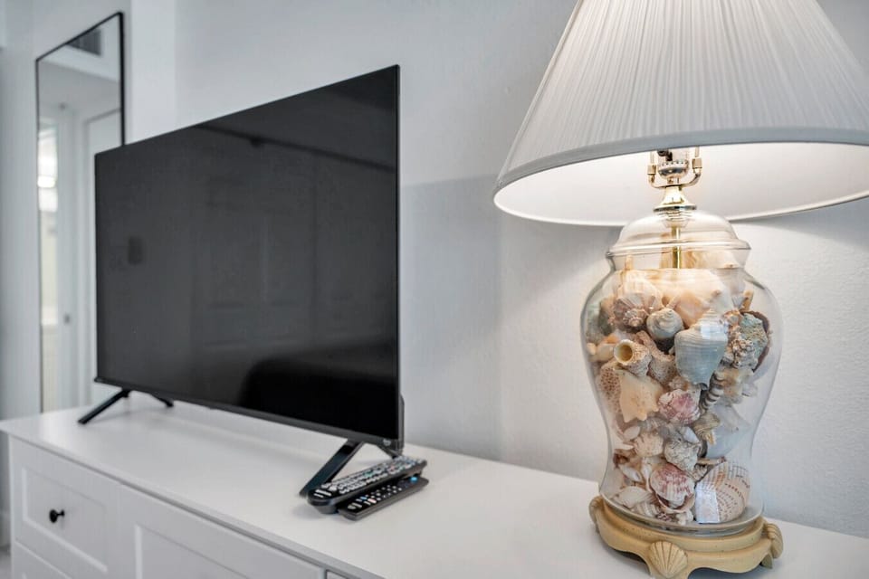Bedside view w/ TV and decorative lamp, perfect for winding down in the evening.