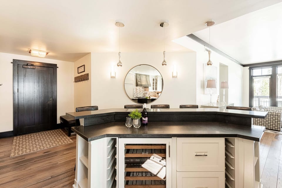 Center island with bar seating and a dual-zone wine fridge