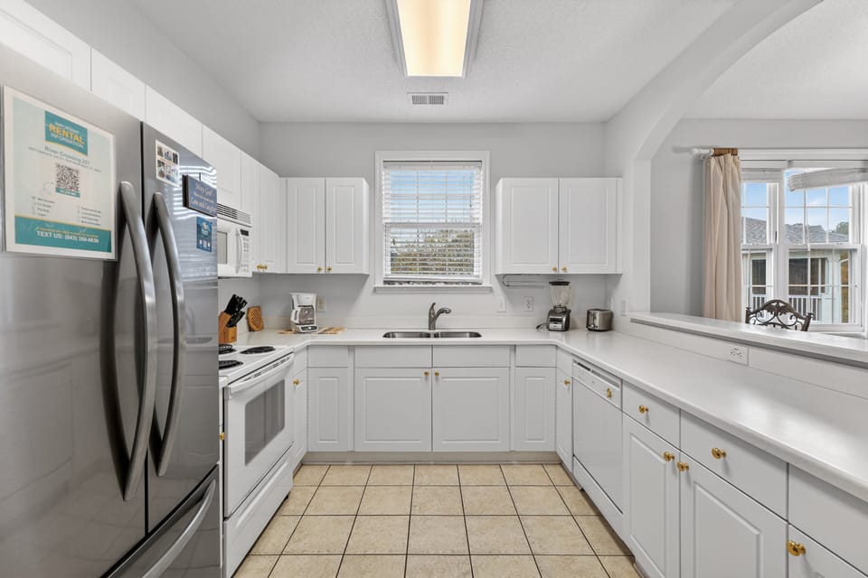 Clean, bright kitchen with full-size appliances and everything needed for cooking at home.
