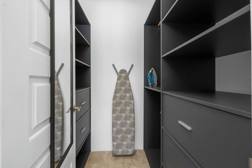 Unpack, unwind and stay organized with a spacious walk-in closet. Designed for ultimate convenience, this well-lit and stylish storage space offers ample shelving, hanging space, and drawers.