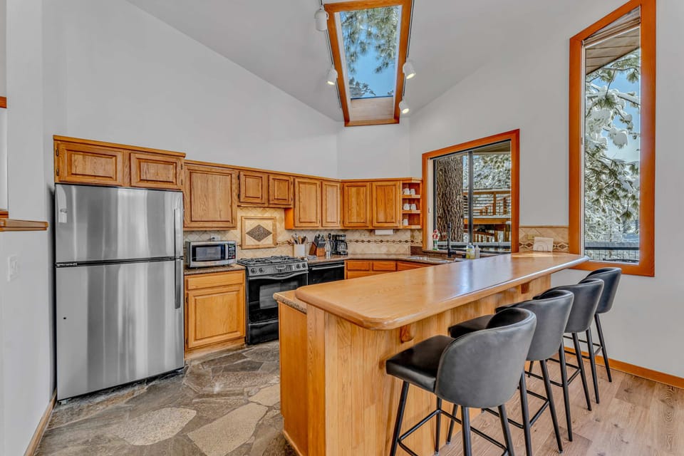Kitchen: Main floor, drip coffee maker, Crockpot, toaster, cooking utensils, tableware, 4 barstools