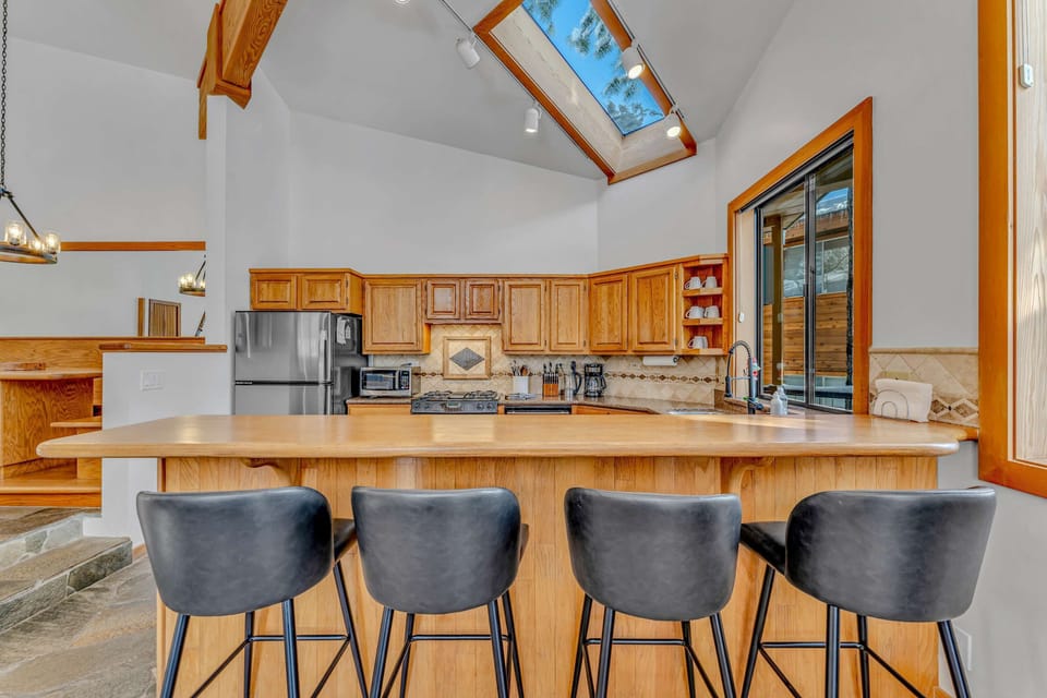 Kitchen: Main floor, drip coffee maker, Crockpot, toaster, cooking utensils, tableware, 4 barstools