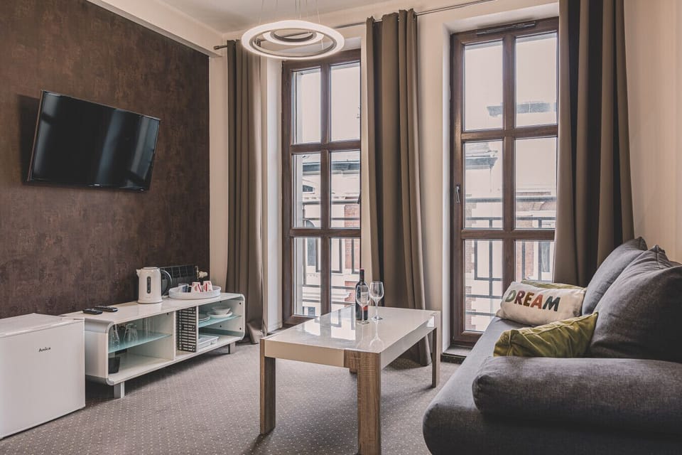 A comfortable living room with a modern design, TV, and large windows. A great place for business and leisure stays in the center of Bydgoszcz!