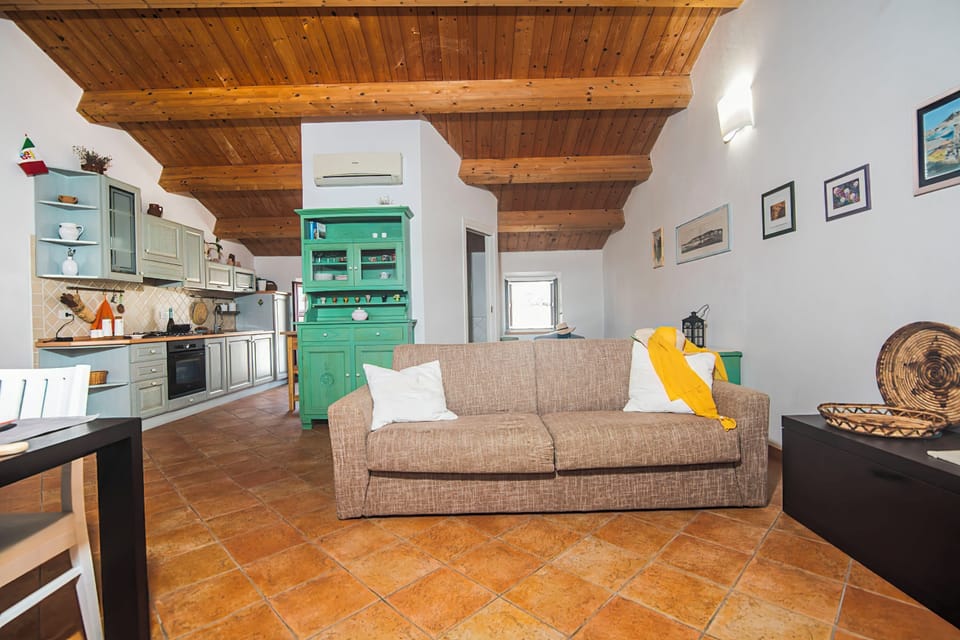Family Studio (Una Mansarda Nell'isola) | Living area | 21-inch flat-screen TV with cable channels