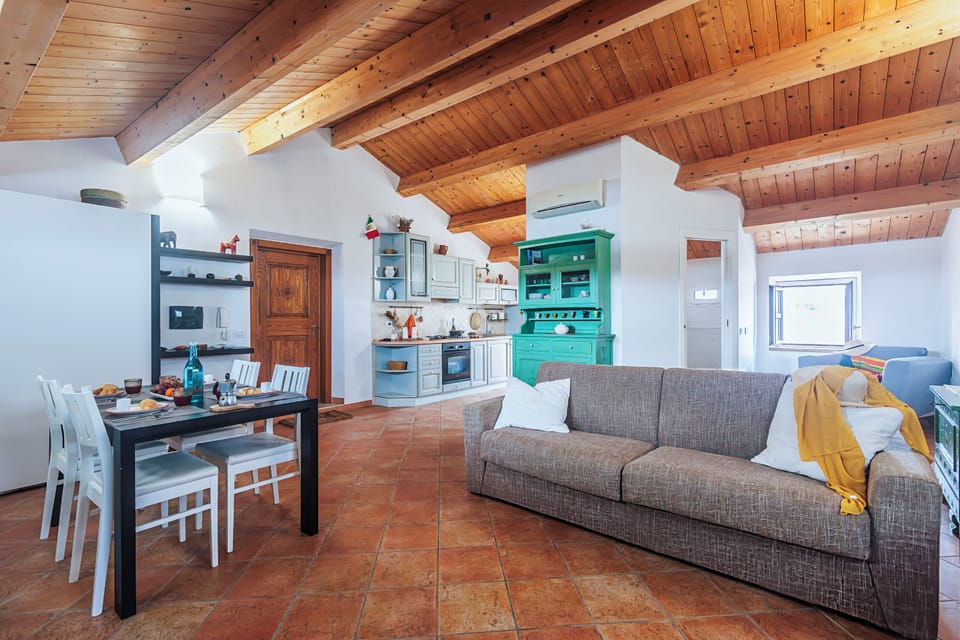 Family Studio (Una Mansarda Nell'isola) | Living area | 21-inch flat-screen TV with cable channels