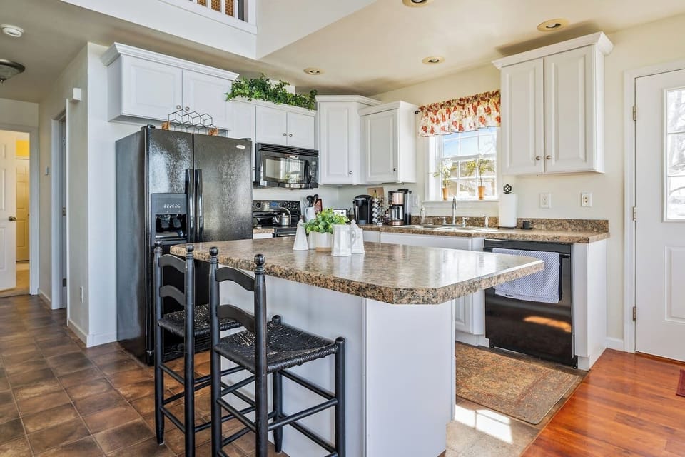 Fully stocked and ready for your culinary creations, this bright kitchen features modern appliances, a large island, and plenty of seating for entertaining! "Lake House"