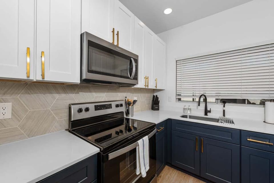 Functional kitchen with oven, stove, fridge and basic cooking ware