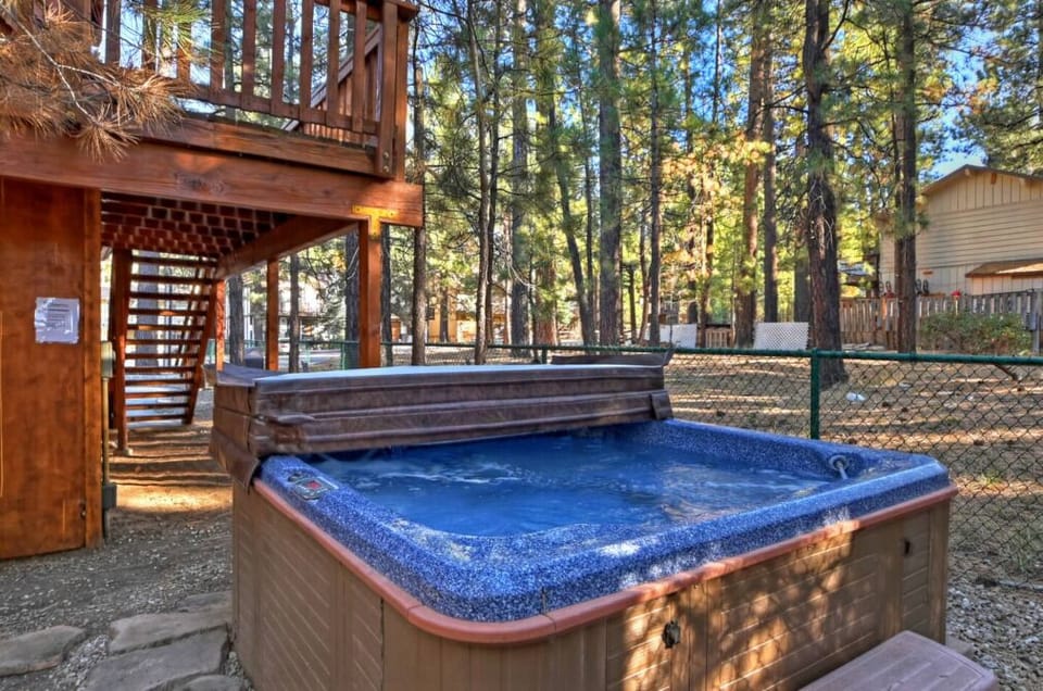Hot tub located out back by patio furniture.
