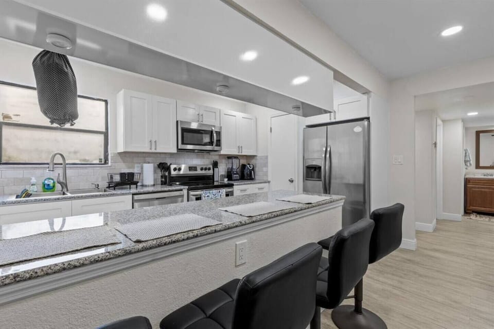Fully stocked kitchen with 4 bar stools for dinning.