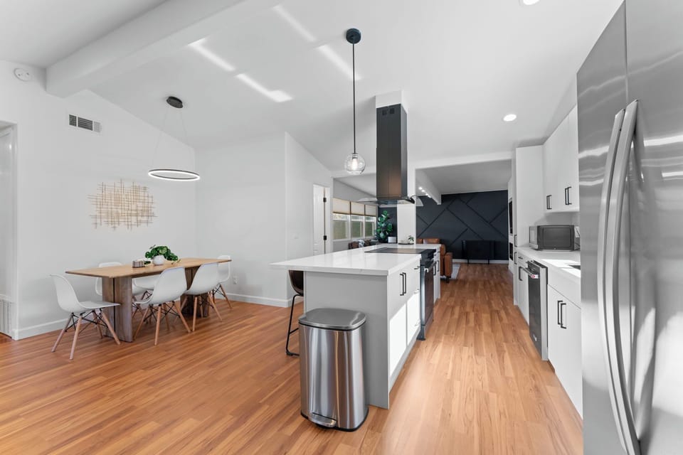 Open concept design connecting living room, kitchen, dining, and gaming area