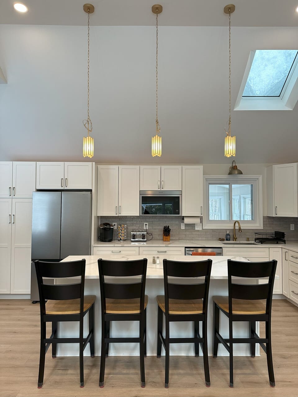 Bright kitchen with 12' ceilings and an island with 4 chairs.