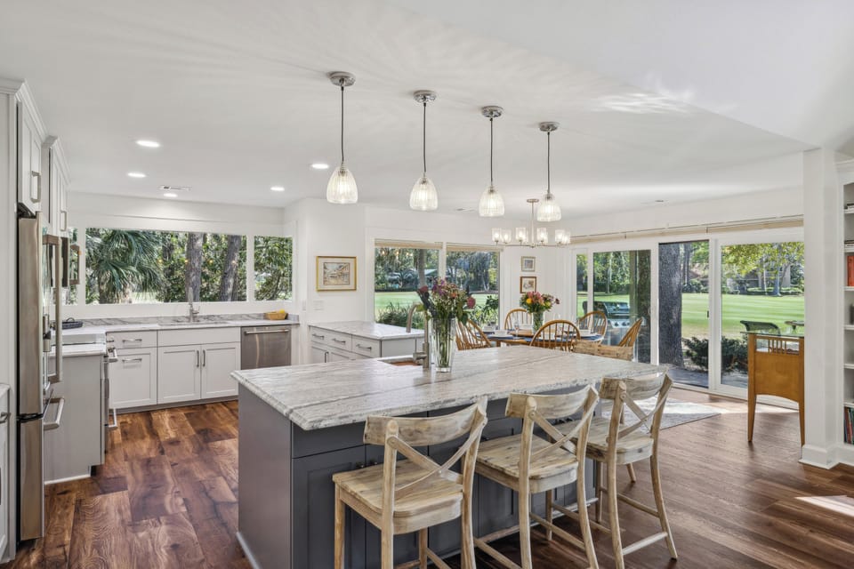 Spacious kitchen with stainless steel appliances and 4 barstools.