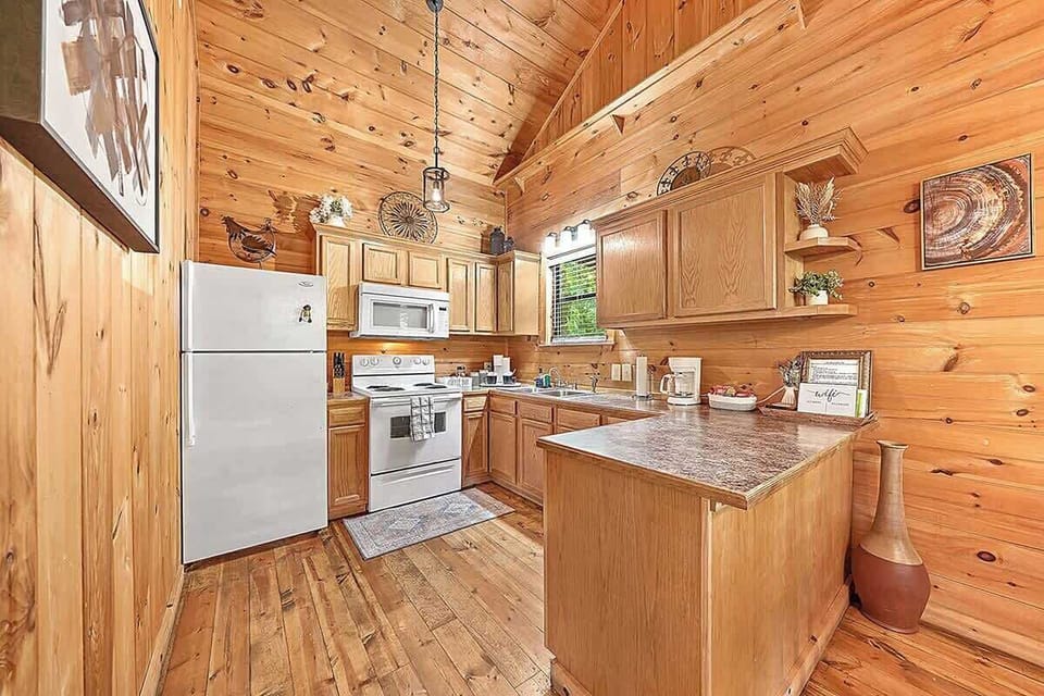 This kitchen provides a stove, microwave, coffee maker, and toaster—paired with a full array of cookware, dishes, and spices. A cozy dining nook for two sits just steps away, perfect for savoring homemade meals.