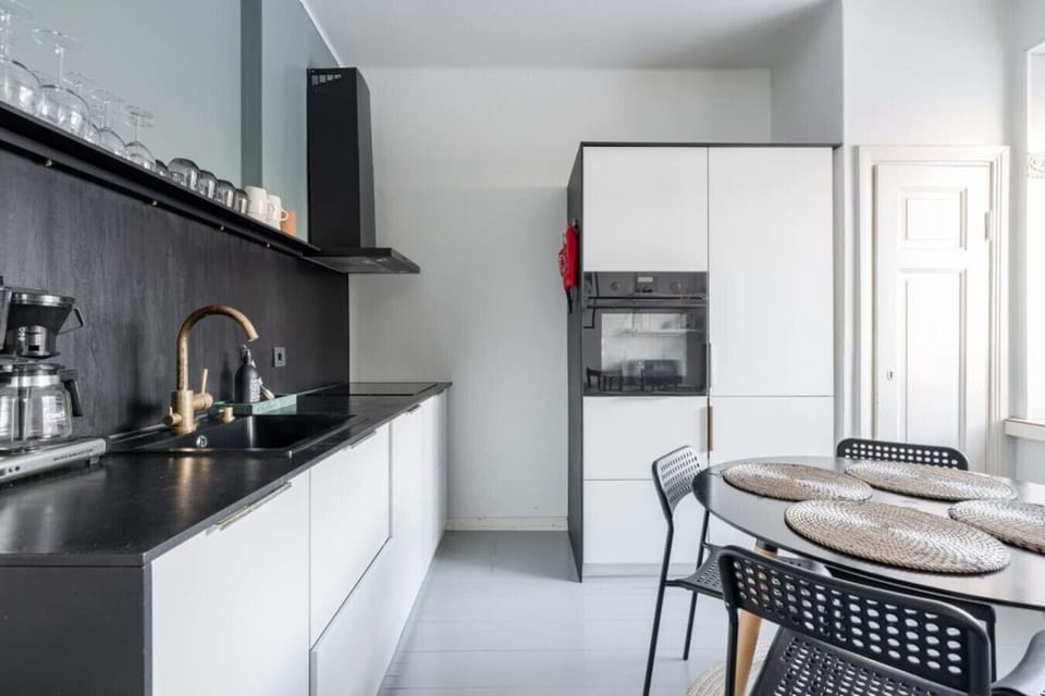 Apartment kitchen that includes oven, microwave, stove, cooker hood, washing machine and a dishwasher for instance
