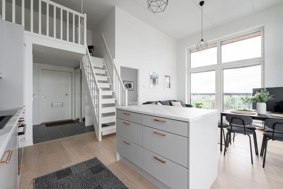 The kitchen island serves as both a practical workspace and a casual spot for morning coffee or quick meals.