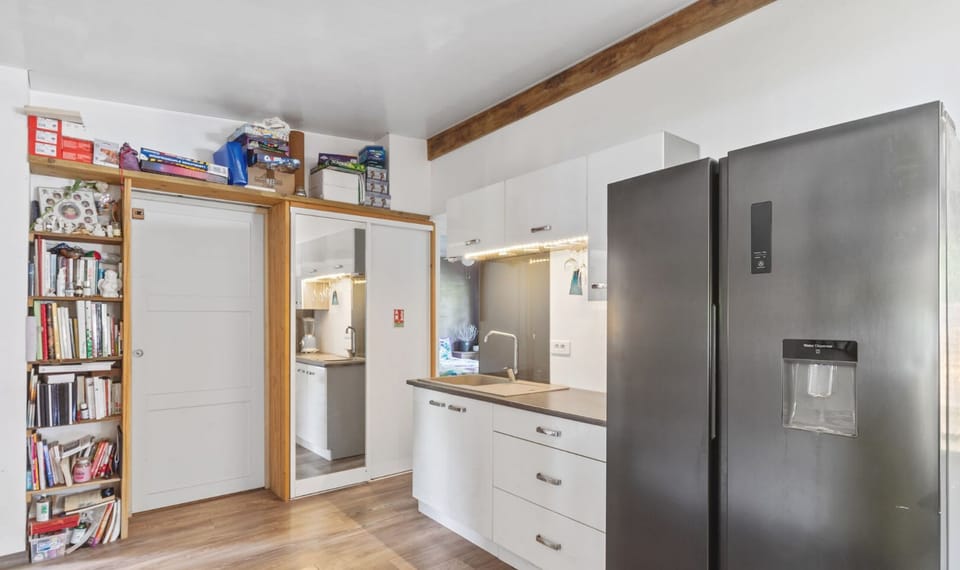 Kitchen with large fridge, storage, and easy access layout.