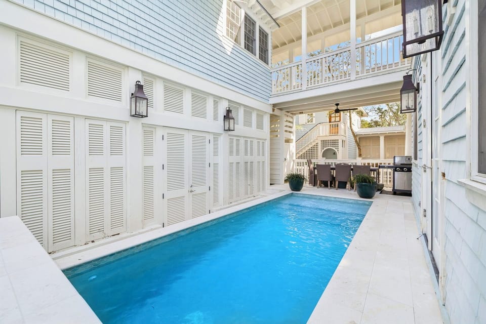 Your private oasis awaits in this stunning courtyard pool, where blue waters shimmer beneath white shutters and balconies.