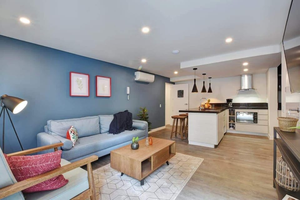 Living room connecting to kitchen with bar serving as dining table. 