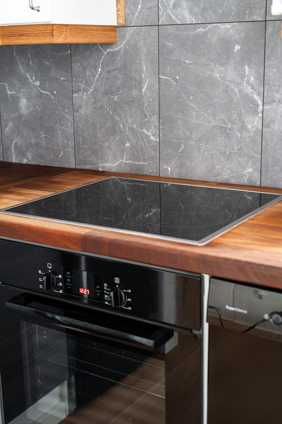 Prepare your meals quickly with the modern, fast-heating induction cooktop integrated into the spacious wooden countertops. All the essential cookware and utensils are stored right beneath it for your convenience.
