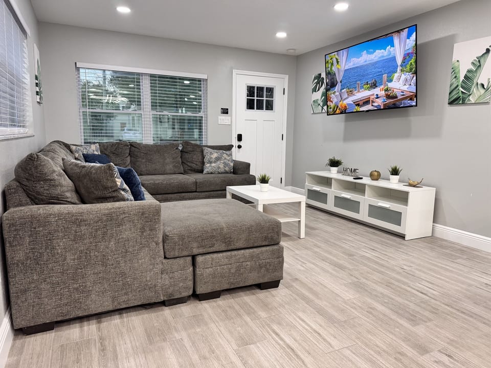 The decor in the living area is a blend of modern sophistication and cozy charm, featuring neutral tones, clean lines, and tasteful accents.