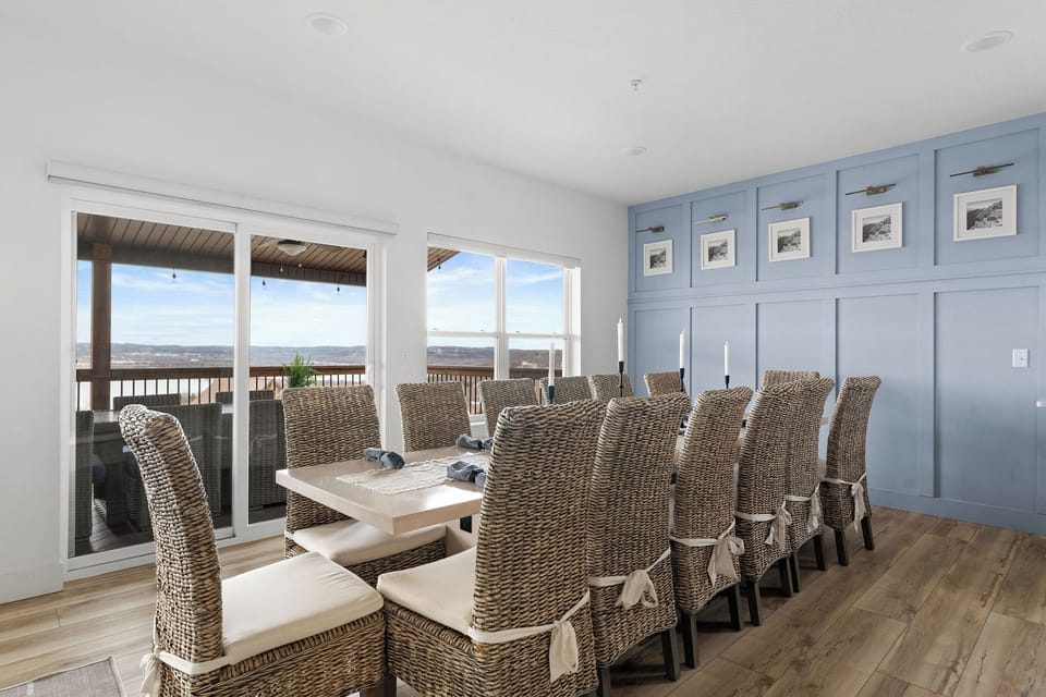 - Gather around the oversized dining table for shared meals, laughter, and unforgettable moments
- Seating for fourteen ensures everyone has a spot at the table
- Wicker chairs and blue panel wall add natural charm and personality to the space