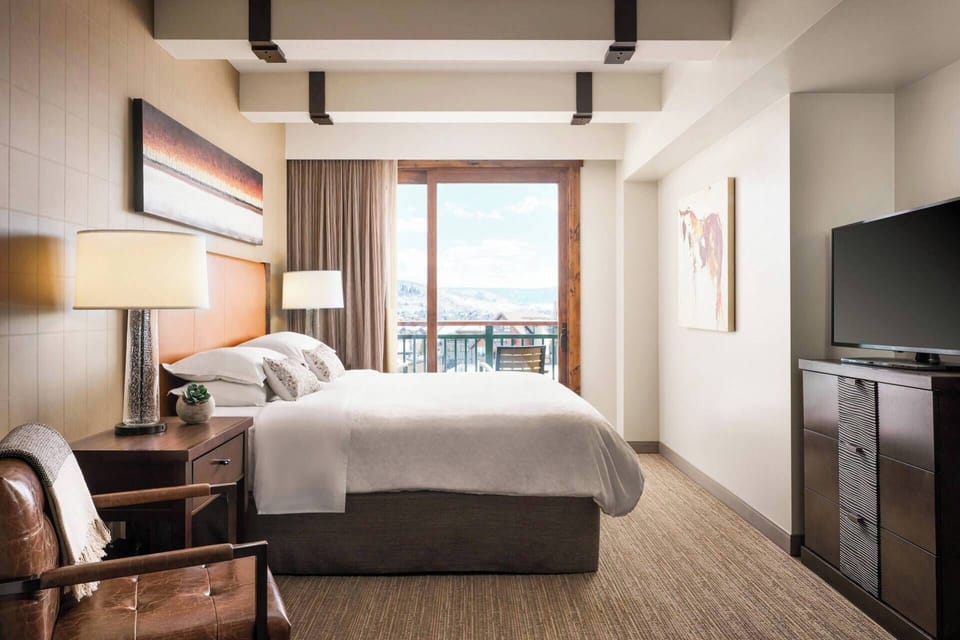 Primary Bedroom features a king bed, chair, TV, door to the patio, and ensuite bath.