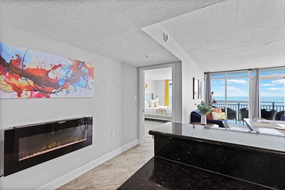 Enjoy cozy vibes and stunning ocean views in this stylish beachfront condo! Featuring a modern electric fireplace, bold artwork, and open layout, it’s the perfect blend of comfort and coastal charm in the heart of Myrtle Beach.