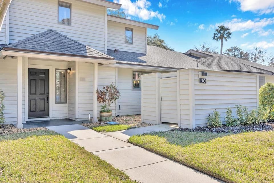Charming townhome entrance with a private fenced courtyard and easy sidewalk access.