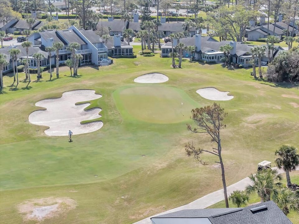 Aerial view of golfers in action on the surrounding greens.