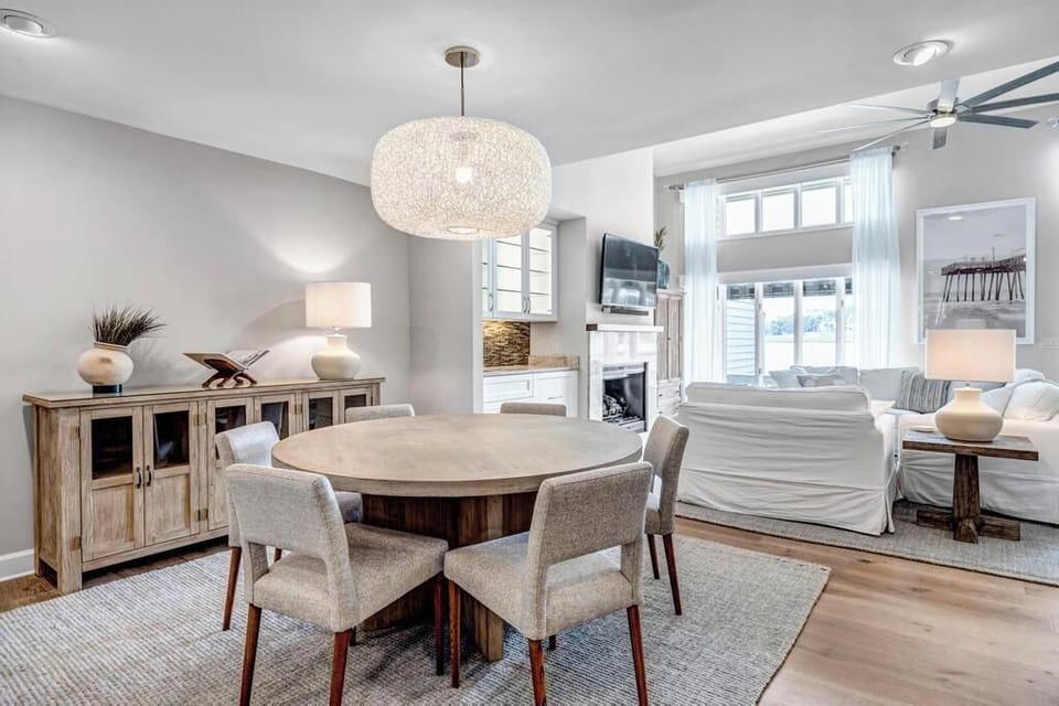 - Gather around this circular dining table with plush chairs and warm ambient light
- Beautiful coastal accents and neutral tones create a welcoming atmosphere
- Enjoy views of the living space while sharing meals or playing games