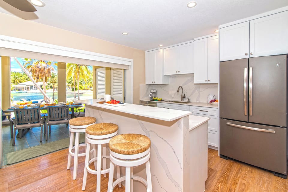 Full kitchen with island seating and walkout access to the atrium. 