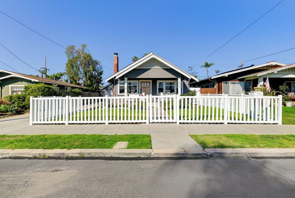 The home is enclosed by this white fence with a gate directly in front.