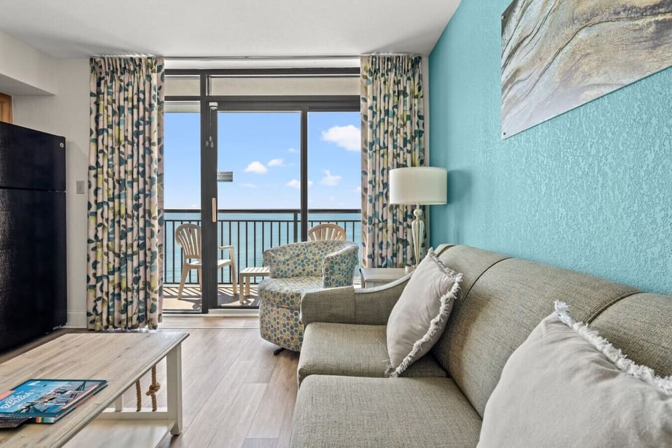 Relax in this stunning 11th-floor oceanfront living room with breathtaking beach cove views. Enjoy a spacious balcony, smart TV, fully stocked kitchen, and  dining area perfect for a serene coastal getaway. Book your stay and wake up to the waves!