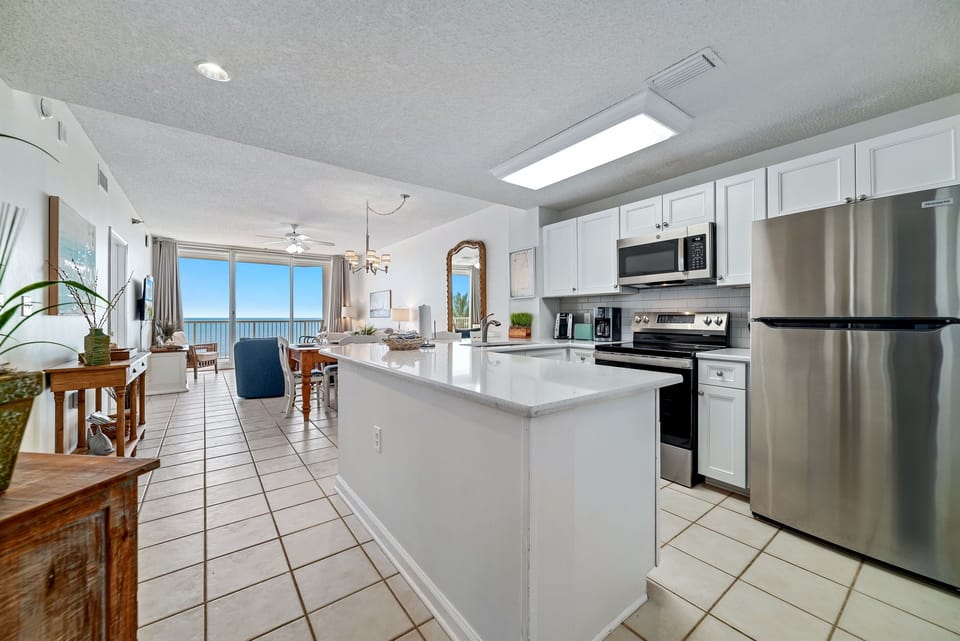 This fully functional kitchen boasts stainless steel appliances, sleek countertops, a decorative backsplash, and ample cabinet storage, ideal for everyday cooking and entertaining.
