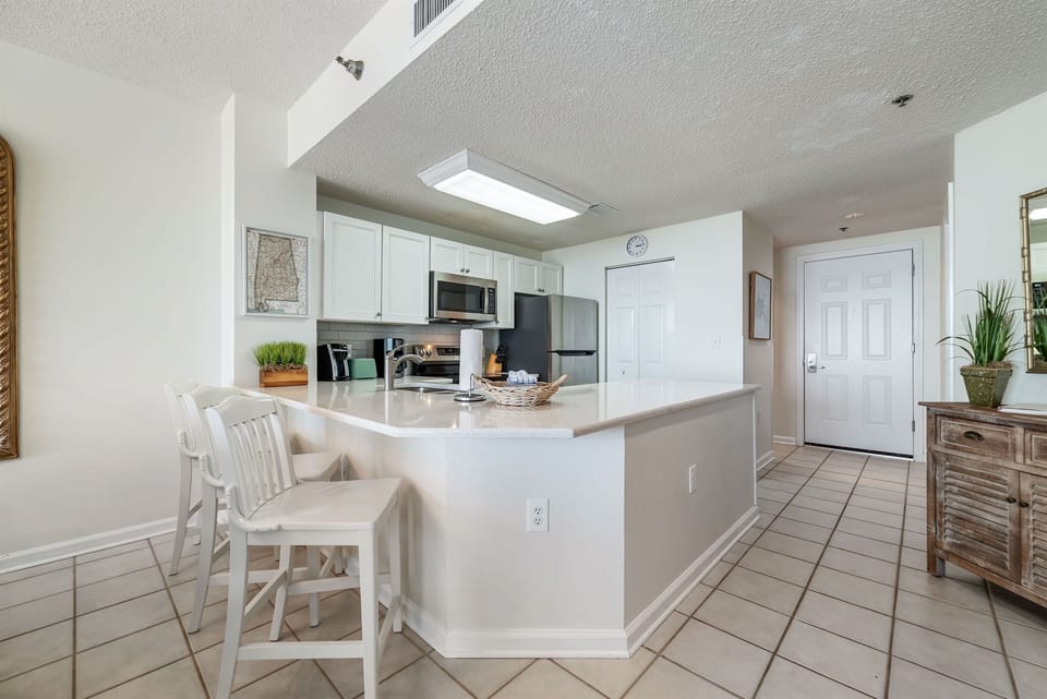 Sleek and sophisticated kitchen featuring a striking island with a stone countertop and comfortable bar stools.