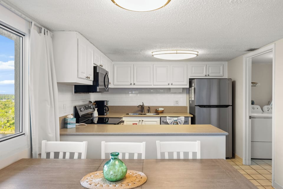 Enter the fully equipped kitchen with a spacious peninsula perfect for prep or serving the family.