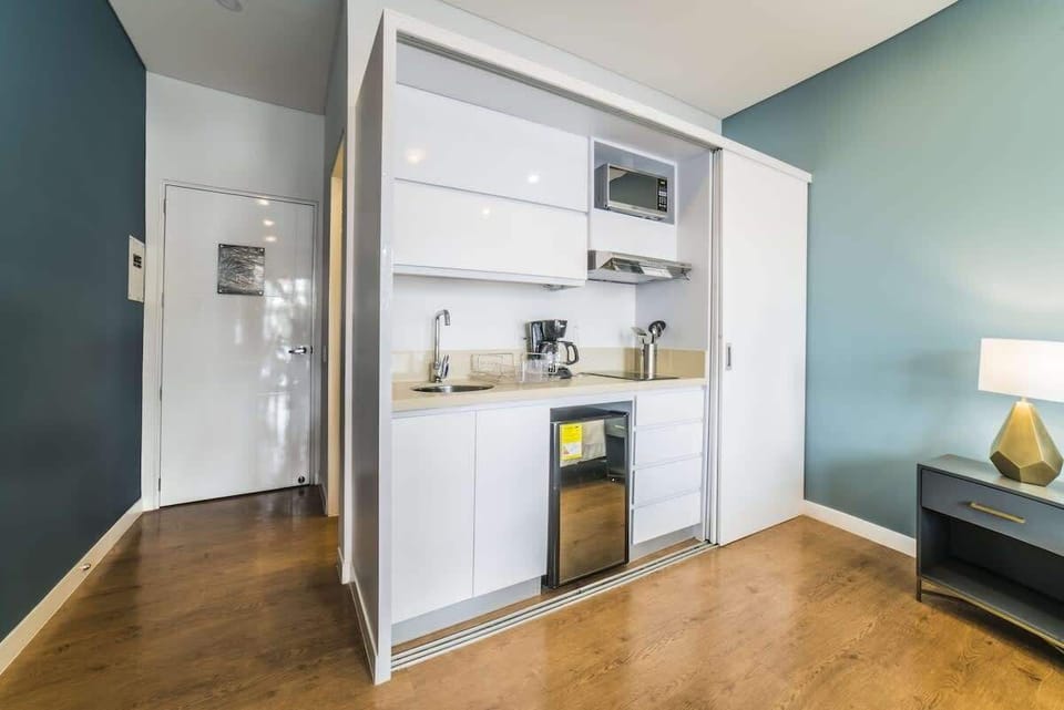 Small kitchen with mini fridge, coffee maker, micro wave and stove.