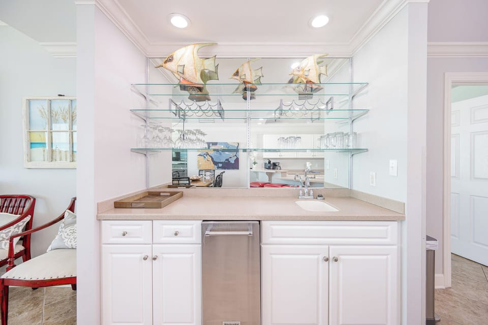 Glass shelves reflect shimmering fish as you prepare refreshing drinks at the wet bar