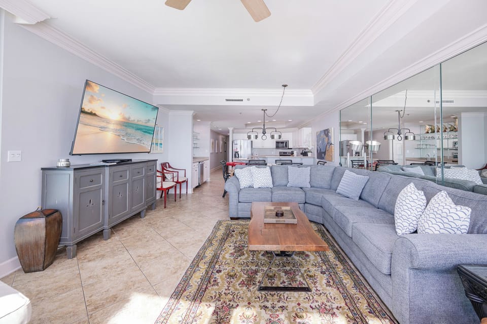 A large gray couch surrounds you as you unwind watching your favorite shows in the living room