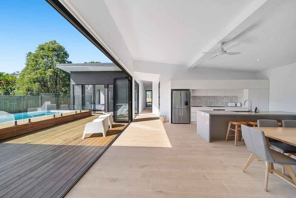 Private pool bordered by wooden deck, surrounded by sun loungers.