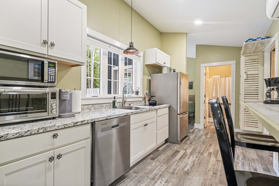 Modern kitchen with an electric range, toaster oven, microwave, dishwasher, refrigerator and coffee maker