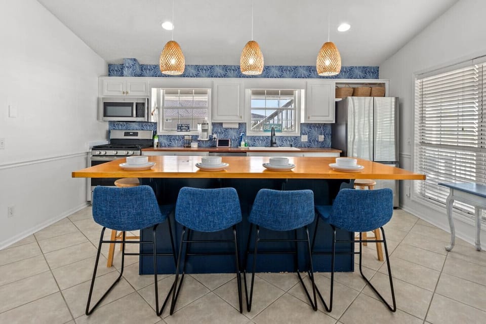 A dining table for four with a view of the kitchen creates a cozy and inviting atmosphere. It’s perfect for casual meals, allowing guests to enjoy the conversation and the action happening in the kitchen, making the space feel open and connected. Whether 