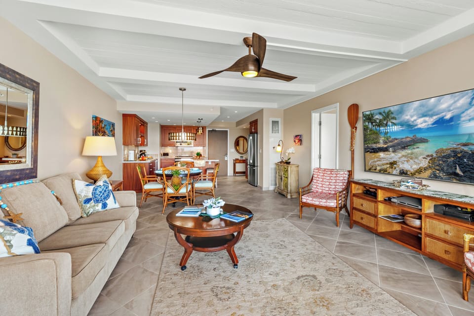 Spacious open-concept living area featuring coastal-inspired décor, comfortable seating, and a beautifully coordinated dining and kitchen space—creating a welcoming island retreat perfect for relaxing or entertaining.