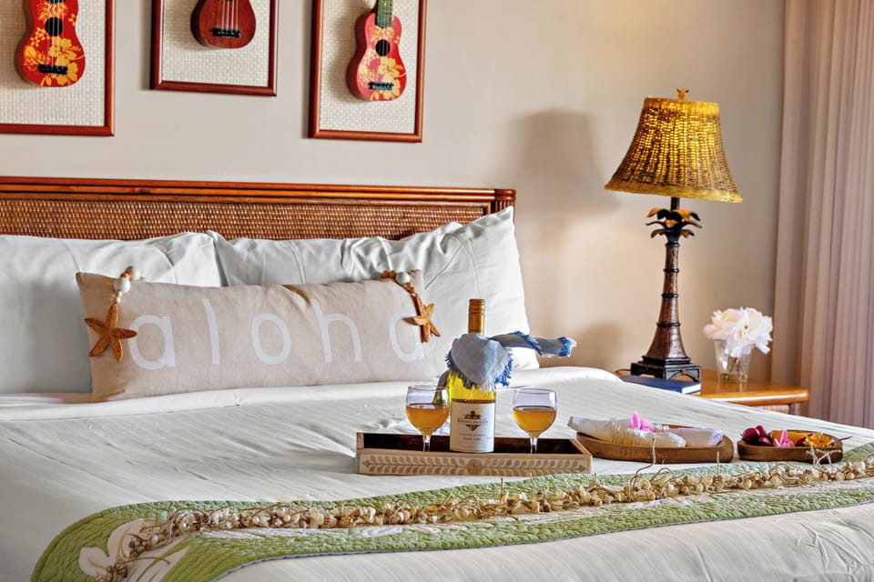Primary bedroom detail featuring a plush, elegantly dressed bed with island-inspired accents and a thoughtfully styled breakfast tray—adding a refined touch of comfort and coastal charm.