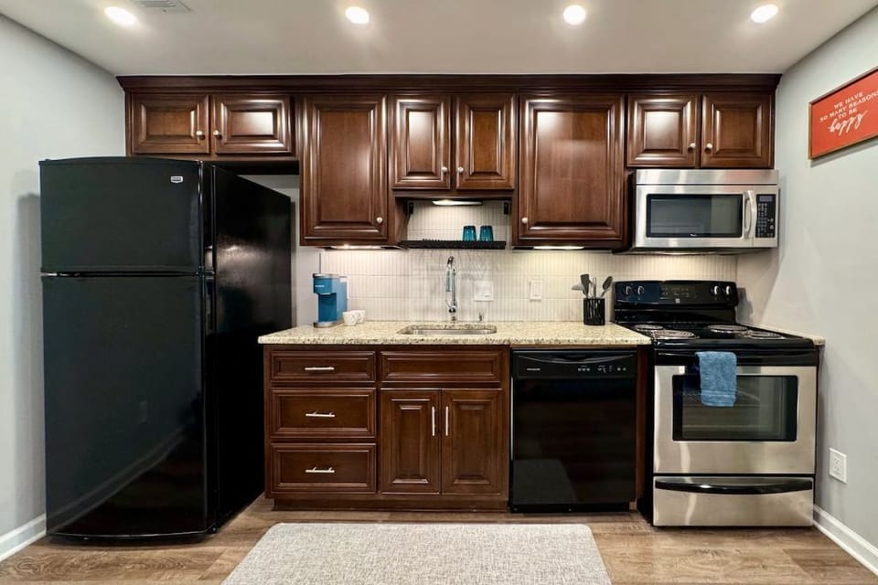 A fully equipped kitchen with modern appliances and rich wooden cabinetry.