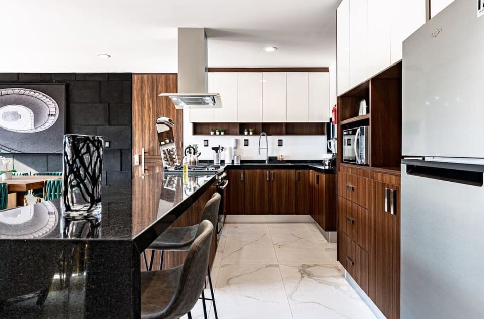 Dining space set next to a striking stone wall with abstract art
