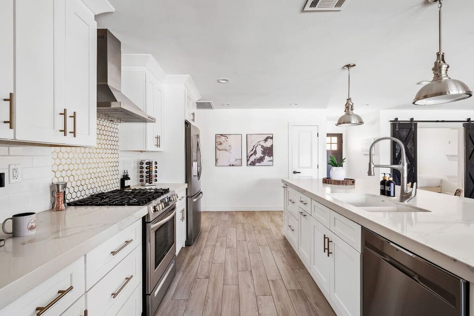Super spacious, modern kitchen featuring an oversized island and fully stocked with premium essentials, including cookware, blender, wine glasses, toaster, coffee maker, spices, and more.